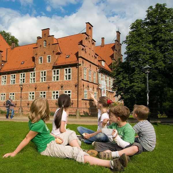 im Gras sitzende Kinder vor dem Bergedorfer Schloss